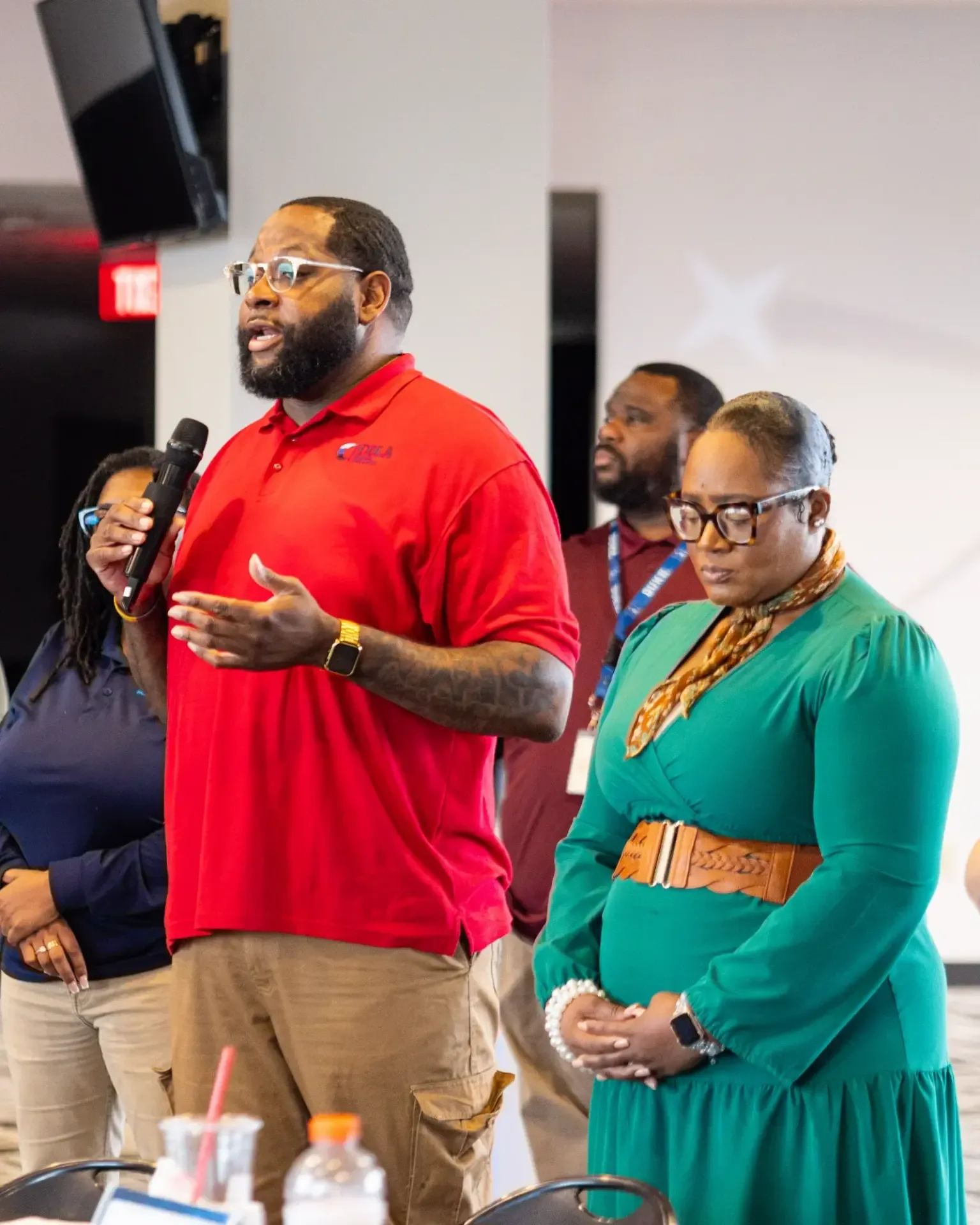 Community leader speaking into a microphone at a Project OneWay gathering